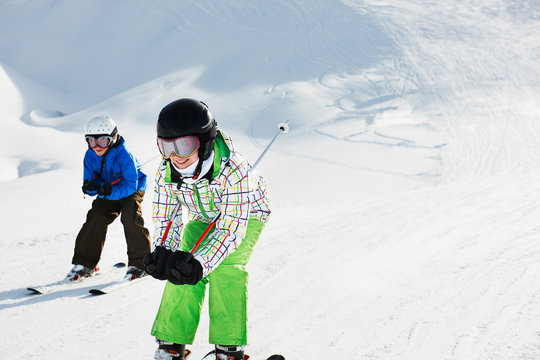 Brother and sister skiing downhill, Les Arcs, Haute-Savoie, France