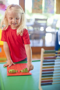 Girl counting with fingers at nursery school