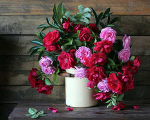 Garden roses in cans on the table.