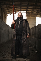 Portrait of a bald man from post-apocalyptic world with rifle in leather clothing as style Fallout...