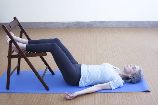 Mature woman resting legs on chair