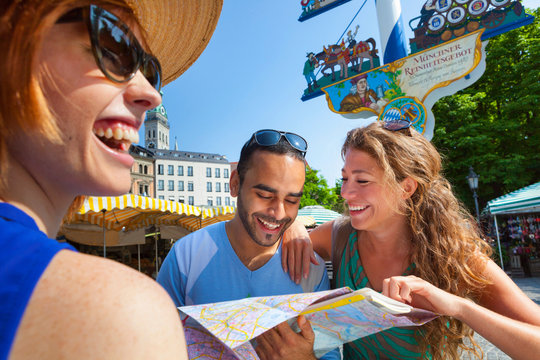 Friends looking at map in Munich Viktualienmarkt, Munich, Germany