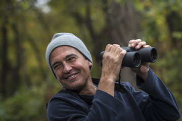 Mature man holding binoculars