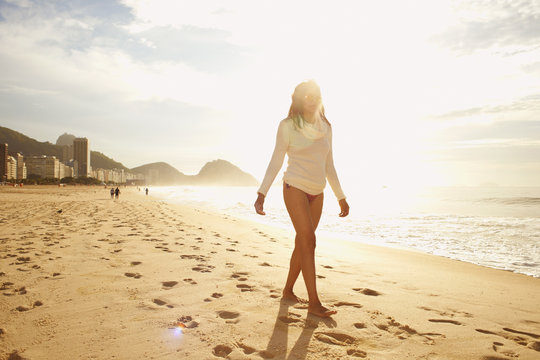 Mature woman strolling on sunlit Copacabana beach, Rio De Janeiro, Brazil