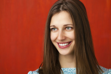 Portrait of a beautiful young woman in a turquoise dress on red