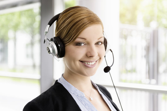 Portrait of young businesswoman in telephone headset