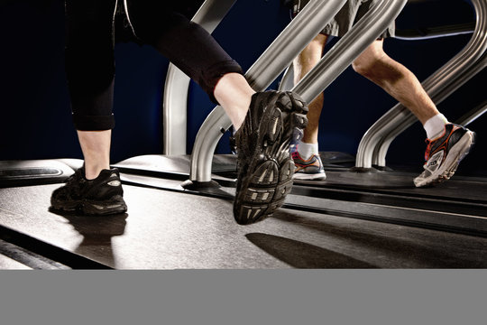 Close up of male and female legs running on gym treadmill in altitude centre