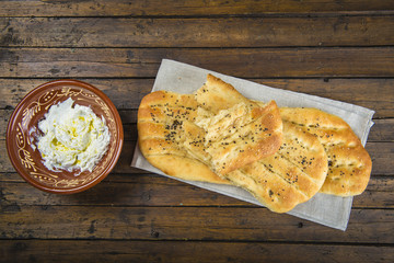 Pan plano persa con semillas de sésamo y queso fresco tipo labneh con aceite de oliva, comida tradicional de oriente medio