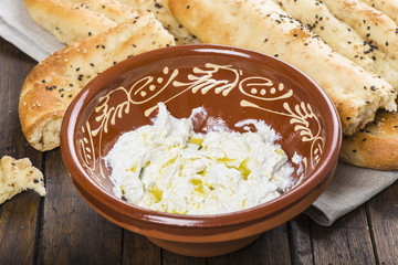 Pan plano persa con semillas de sésamo y queso fresco tipo labneh con aceite de oliva, comida tradicional de oriente medio