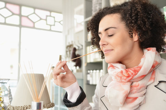 Young woman smelling joss sticks in boutique