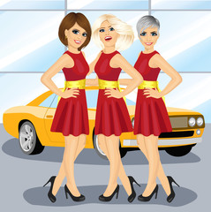 Three beautiful hostess women by the yellow car on motor show