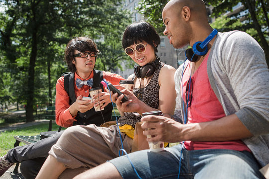 Three friends in park with mp3 player