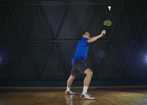 Young man playing badminton on court