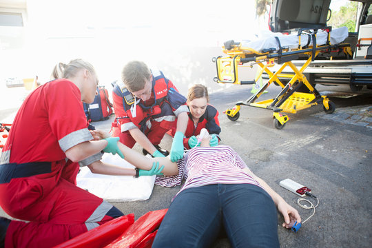 Three paramedics tending patient on road