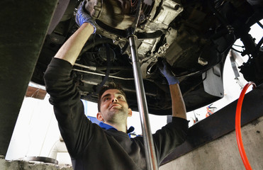 Mechanic checking car undercarriage