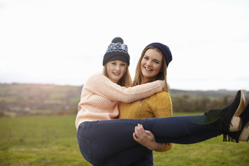 Teenage girl being lifted up by best friend