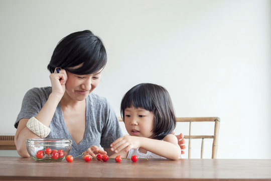 Mother and daughter counting cherries