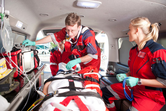 Paramedics checking patient in ambulance