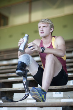 Sprinter sitting with prosthetic leg on