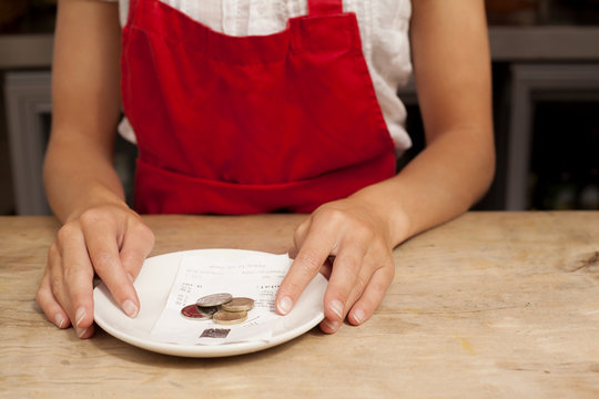 Close up of waitress with bill and gratuity at kitchen counter