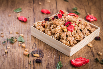 Homemade granola with dried berries on a wooden background