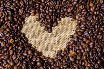 Kaffeebohnen als Herz mit Jute als Hintergrund