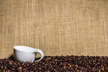 Kaffeetasse auf Kaffeebohnen mit Jute als Hintergrund