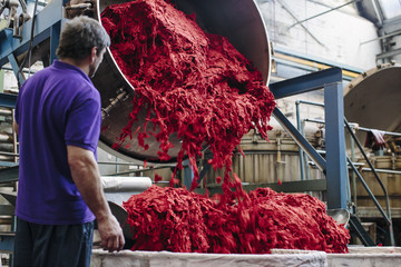 Male factory worker dyeing wool in woollen mill
