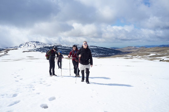 Four men hiking in snow, Bucegi Mountains, Transylvania, Romania