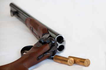 Opened double-barrelled gun with bullets photo isolated on white