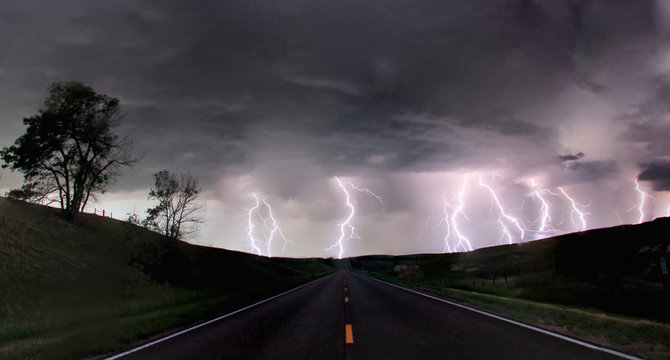 A composite image from 5 images of  cloud-to-ground lightening bolts at the end of a rural road, Lexington, Nebraska, USA