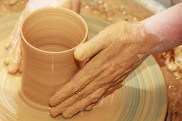 Töpferscheibe, zwei Hände formen Becher aus Ton
