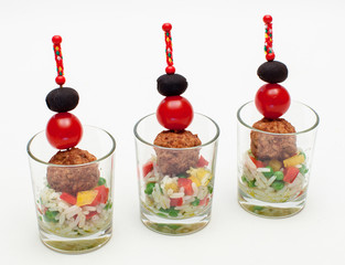 Frikadellen-Spieße auf buntem Reissalat im Miniglas