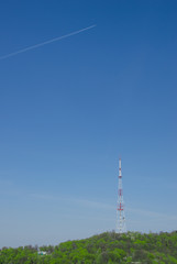 Obraz premium The Television Tower on hill and airplane in sky