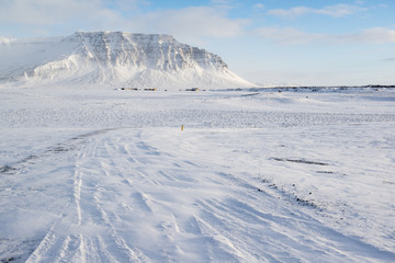 Fototapeta na wymiar Winter landscape with mountain, a lot of snow and small farm houses, Iceland