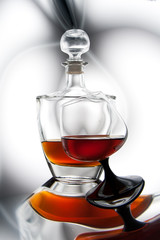 Bottle and a glass of cognac with reflection