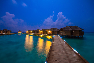 Fototapeta premium Over water bungalows with steps into amazing green lagoon 