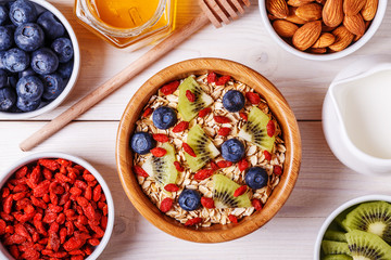 Healthy breakfast - bowl of oat flakes with fresh fruit, almond.