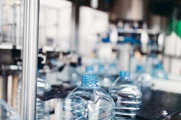 Robotic factory line for processing and bottling of pure spring water into canisters and bottles. Selective focus.