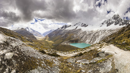 panorama of snow-covered Andes mountains and blue lake
