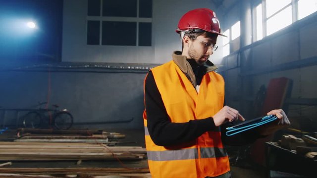 Steadicam shot: Engineer working in the warehouse with the tablet