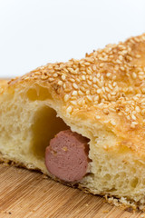 Sliced sausage roll on the wooden kitchen board