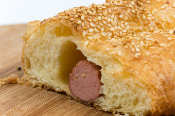 Sliced sausage roll on the wooden kitchen board