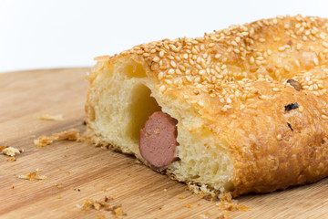 Sliced sausage roll on the wooden kitchen board