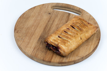 Puff pastry with red cream on the wooden board