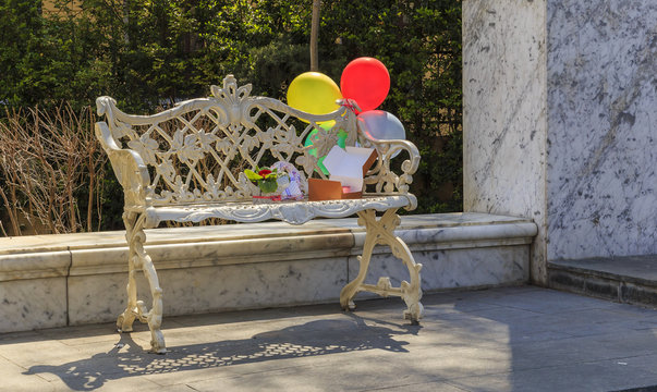 Balloons tied to an old bench and boxes with gifts