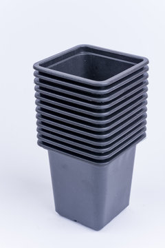 Pile of black plastic flower pots isolated over white background