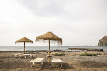 Sonnenschirme und Strandliegen am Meer
