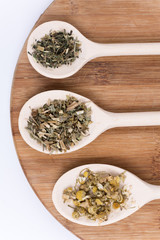 Chamomile tea nettle and basil on a wooden spoon