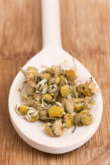 Chamomile tea on a wooden kitchen spoon